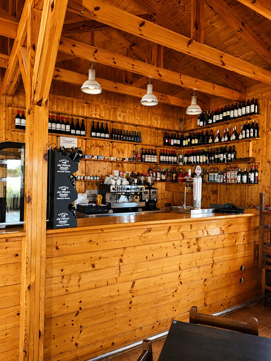 Barra de madera con estanterías de vinos