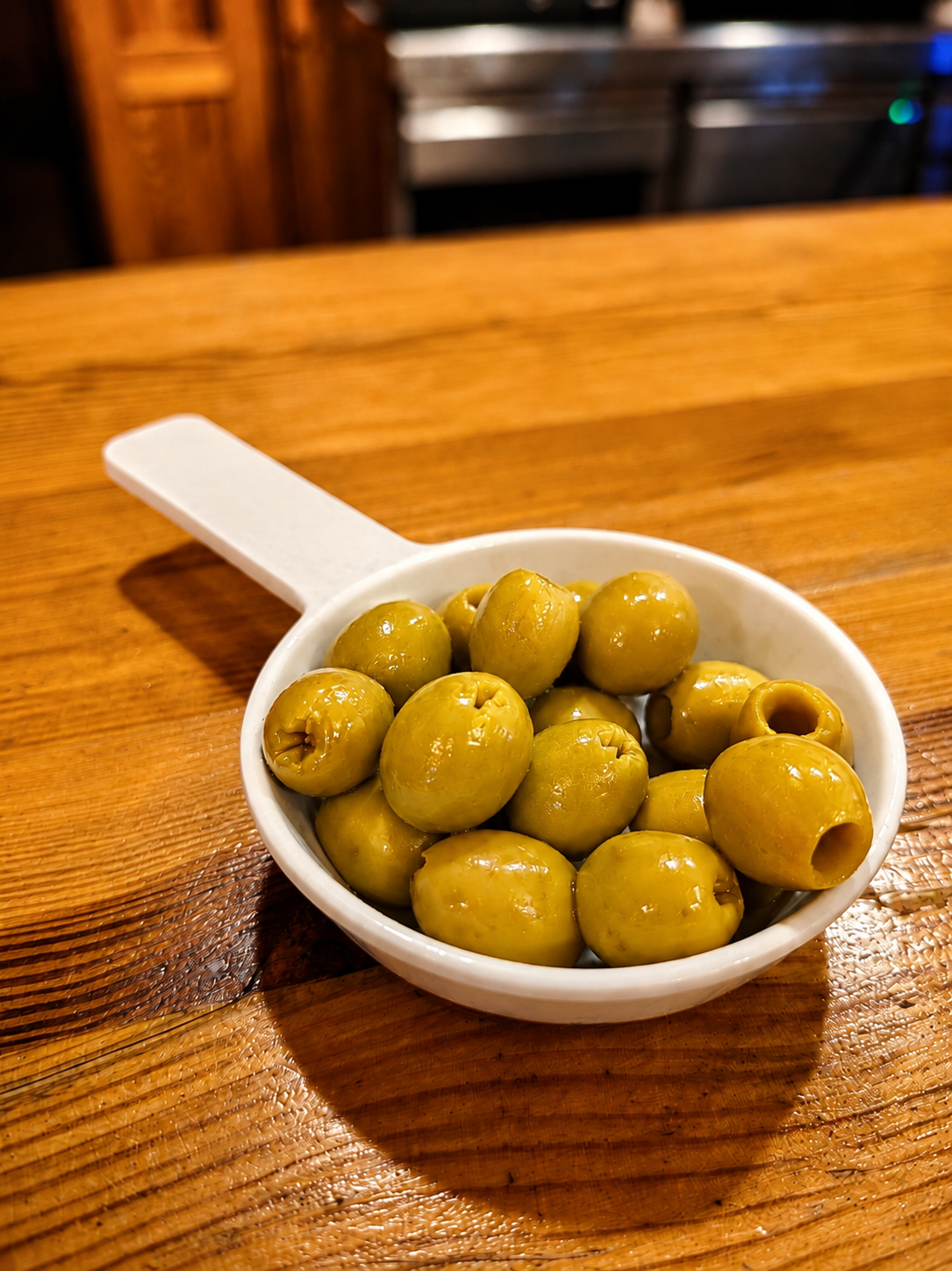Aceitunas rellenas de anchoa en cazuelita sobre la barra de madera